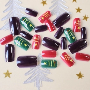 Christmas themed glossy false nails in multi-color with gold stars and line patterns