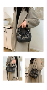 Close-up of black ruched cloud bag with vintage leather texture and silver chain strap