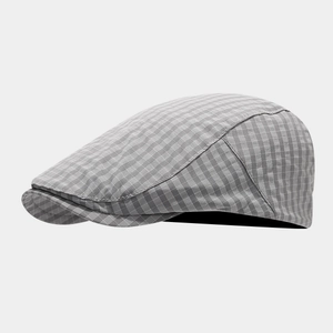 Close-up of grey and white plaid newsboy cap showing detailed woven texture and stitching