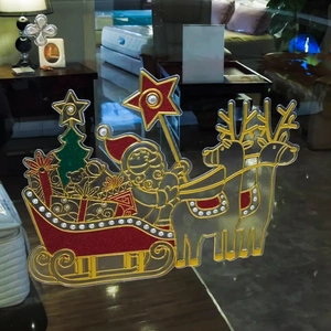 Christmas window sticker featuring Santa Claus on a reindeer sleigh with red glitter detail