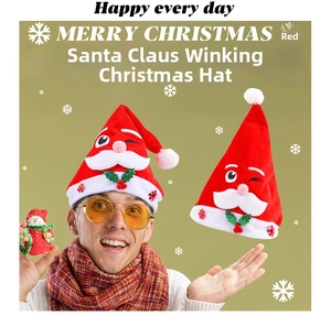 Detail of red Santa hat featuring a winking cartoon character with plush white ball and leaves