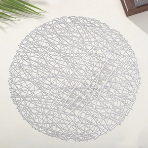 Silver round PVC hollow woven placemat for dining table setting on white background
