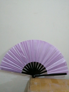 Detail view of a purple fabric kung fu fan with black bamboo ribs in semi-open state