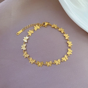 Detail view of butterfly charms on gold-plated stainless steel bracelet with lobster clasp