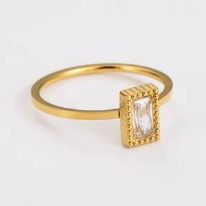 Macro shot of gold stainless steel ring with rectangle zircon and beaded edge detail