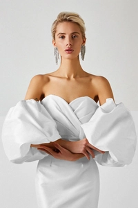 Detailed view of elegant white off-shoulder dress with sculptural puff sleeves and satin finish
