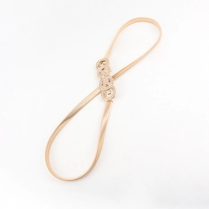 Detail of gold metal elastic snake chain belt with interlocking knot buckle for dresses