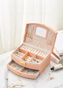 Detail showing pink jewelry box with necklace hooks, ring slots, and a pull-out drawer