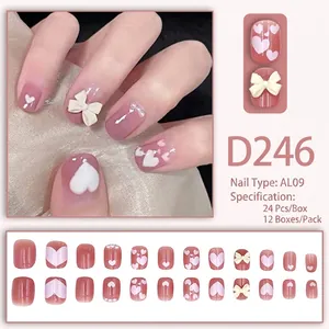 Sweet pink press-on nails with white heart patterns and 3D cream bow decorations