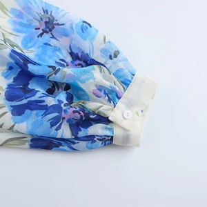Camicetta in chiffon a fiori con maniche a lanterna e polsini bottonati in primo piano