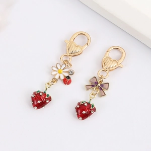 Detailed close-up of 3D strawberry keychains with sparkling rhinestones and heart clasps