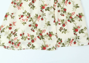Close-up of floral print fabric with red flowers and neat hemline stitching detail