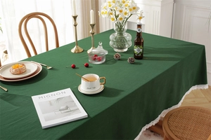 Close-up of dark green cotton tablecloth featuring delicate white lace edge detailing