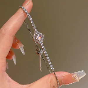 Macro shot of silver zircon flower bracelet with adjustable slide clasp on a model