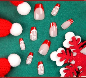 Macro view of Christmas press-on nails with red French tips and Ho Ho art on green background