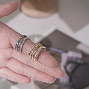 Detail view of gold and silver multilayer crisscross rings with fine zircon inlay on hand