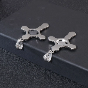 Detailed back view of two silver stainless steel cross pendants on a black display stand