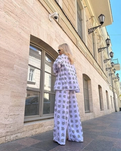 Detail of white two-piece set with black cat print featuring wide-leg trousers and long sleeves