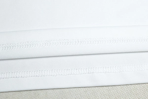 Close-up of double-needle stitching on the white bodycon dress showing high-quality fabric