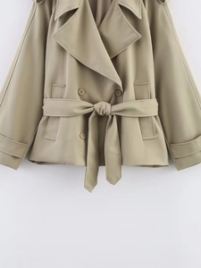 Detail of khaki double-breasted trench jacket with lapels and matching waist belt