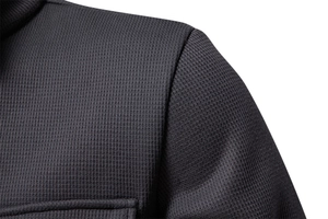 Macro shot of men's fleece waffle jacket showing charcoal gray fabric texture and stitching