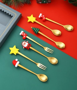 Close-up of golden stainless steel Christmas spoons and forks with silicone cartoon toppers