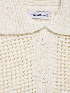 Gros plan détaillé sur le haut en maille crème avec motif au crochet évidé et l'encolure