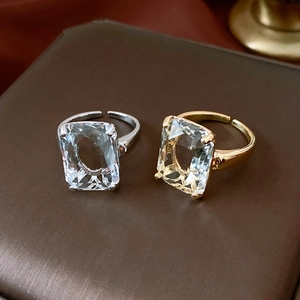 Detail of square-cut crystals set in 14k gold and silver plated open rings on leather