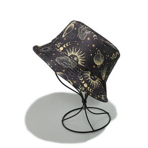 Détail d'un chapeau bob noir avec des motifs d'astrologie dorés et des imprimés célestes
