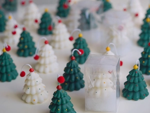 Detailed view of mini Christmas tree scented candles with snow detail in clear gift box