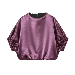 Haut élégant en satin violet à manches courtes avec texture lisse sur fond blanc épuré