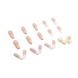 Sparkly nude press-on nails with French glitter tips, rhinestones and pearl bow accents