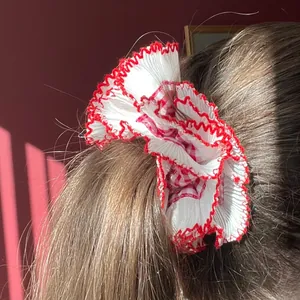 Red and white checkered cotton scrunchie with lace trim edges shown on a ponytail