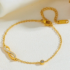Détail d'un bracelet infini doré serti de cristaux avec poinçon en acier inoxydable