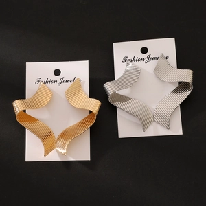 Detailed view of wide wave twisted metal earrings in gold and silver textured finish