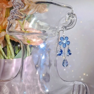Detail of blue butterfly tassel earrings with teardrop pendant and crystal flowers