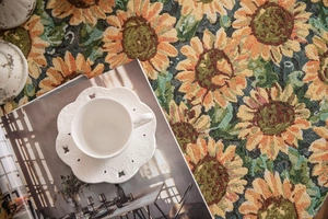 Macro detail of sunflower jacquard tablecloth with elegant hollowed ceramic teacup