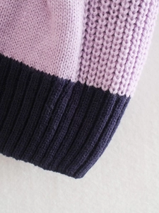 Dettaglio dei polsini a costine in tessuto a maglia a contrasto lavanda e blu navy
