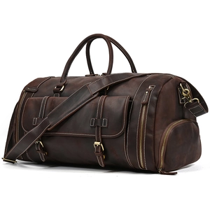 Detail view of large dark brown leather travel bag with vintage buckle pocket and shoe compartment