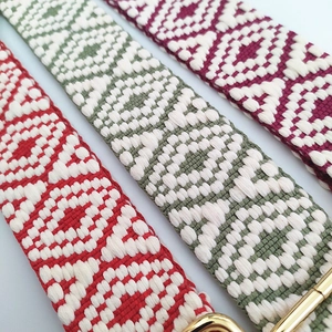 Close-up of multicolored geometric jacquard woven shoulder straps with gold metal hooks