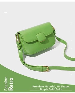 Close-up of bright green rectangular crossbody bag with square buckle and gold hardware
