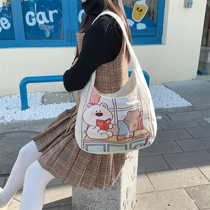 Close-up of cute cartoon bear print on white canvas tote bag with wide shoulder strap