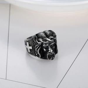 Macro detail of vintage stainless steel ring with 3D Jesus relief and cross engraving