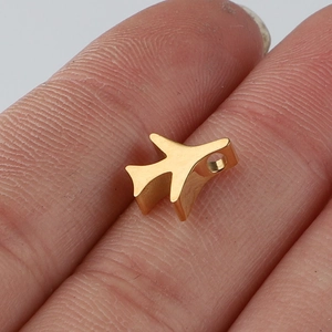 Gedetailleerde close-up van een gouden vliegtuig hanger van roestvrij staal tussen vingers