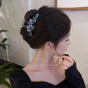 Détail de l'élégante pince à cheveux camélia bleu dégradé sur la coiffure du mannequin