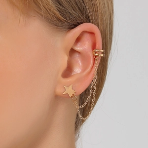 Detailed view of gold star chain earring with integrated ear cuff and stud design