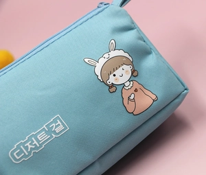 Dettaglio dell'astuccio azzurro con simpatica ragazza cartoon e chiusura a cerniera