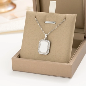 Detail of silver geometric square pendant necklace with crystal border in a jewelry box