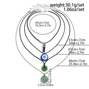 Detailed view of bohemian layered necklaces featuring mandala pendant and evil eye bead