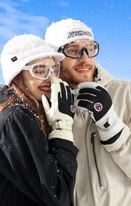 Close-up of waterproof winter ski gloves with anti-slip palm on snow background